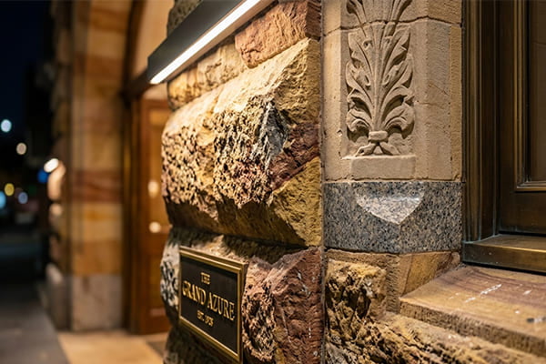 A close-up of a high-end hotel's stone facade lit by a CRI 90+ wall washer.
